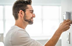 Man adjusting thermostat