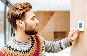 Man adjusting thermostat